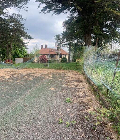 6 This is a photo of a tennis court in Surrey that is in need of refurbishment